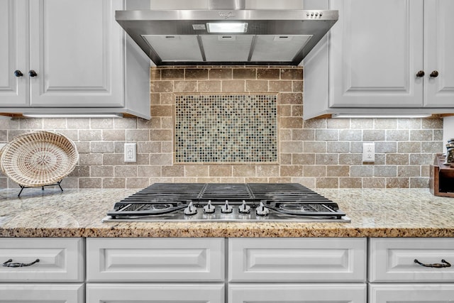 kitchen featuring white cabinets, tasteful backsplash, stainless steel gas cooktop, and extractor fan