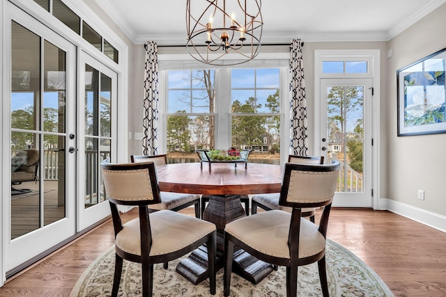 dining area featuring light wood-style flooring, ornamental molding, and a wealth of natural light