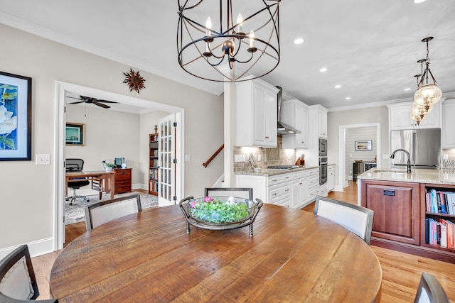 dining area with recessed lighting, crown molding, light wood-style flooring, and baseboards