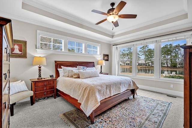 bedroom featuring a tray ceiling, crown molding, visible vents, a ceiling fan, and baseboards