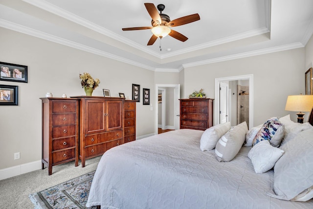 bedroom featuring a raised ceiling, light colored carpet, connected bathroom, ceiling fan, and baseboards