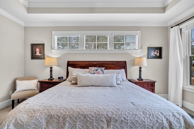 carpeted bedroom with baseboards, multiple windows, a tray ceiling, and crown molding