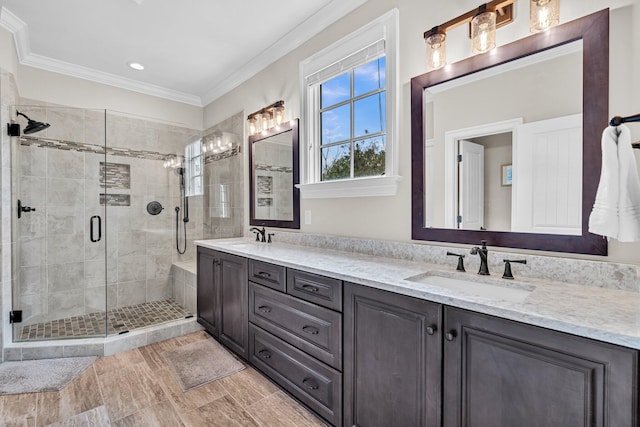 bathroom featuring ornamental molding, a stall shower, a sink, and double vanity