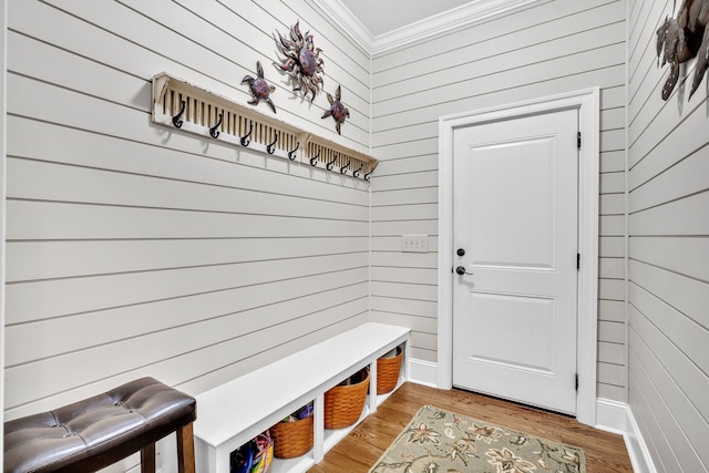 mudroom featuring ornamental molding, light wood-type flooring, and wooden walls