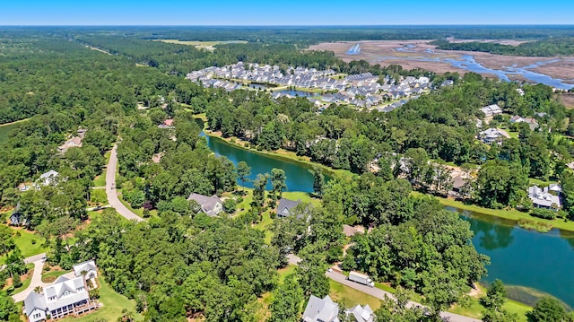 drone / aerial view featuring a water view and a wooded view