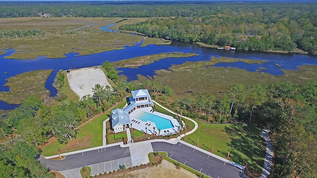 birds eye view of property featuring a forest view and a water view