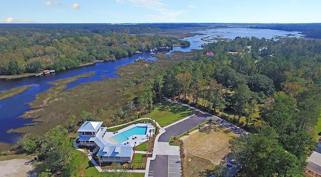 birds eye view of property featuring a forest view and a water view