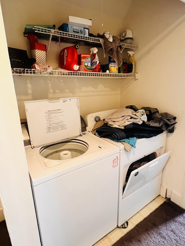 washroom with washing machine and clothes dryer and tile patterned flooring