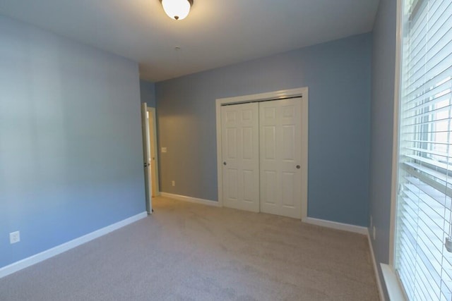 unfurnished bedroom featuring a closet, baseboards, and carpet floors