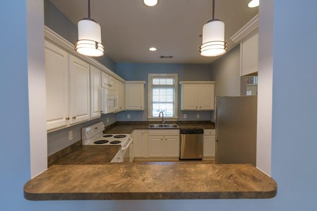 kitchen featuring a sink, dark countertops, a peninsula, recessed lighting, and stainless steel appliances