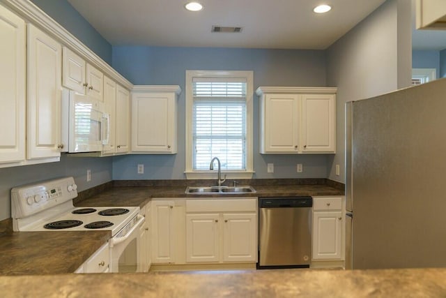 kitchen featuring recessed lighting, white cabinets, visible vents, appliances with stainless steel finishes, and a sink