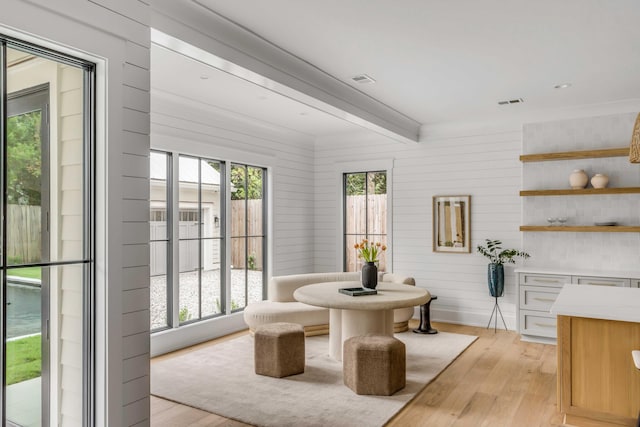 dining room with light hardwood / wood-style flooring and wood walls