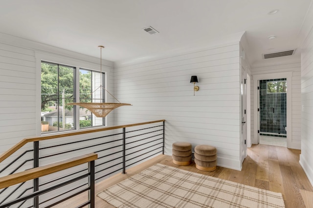 corridor with wooden walls and light hardwood / wood-style flooring