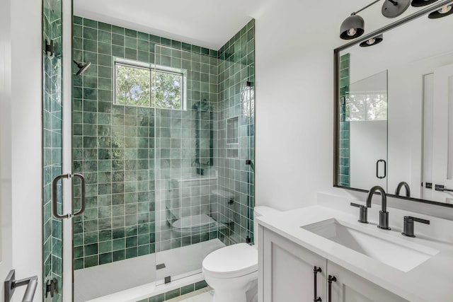 bathroom with toilet, a shower with door, and vanity