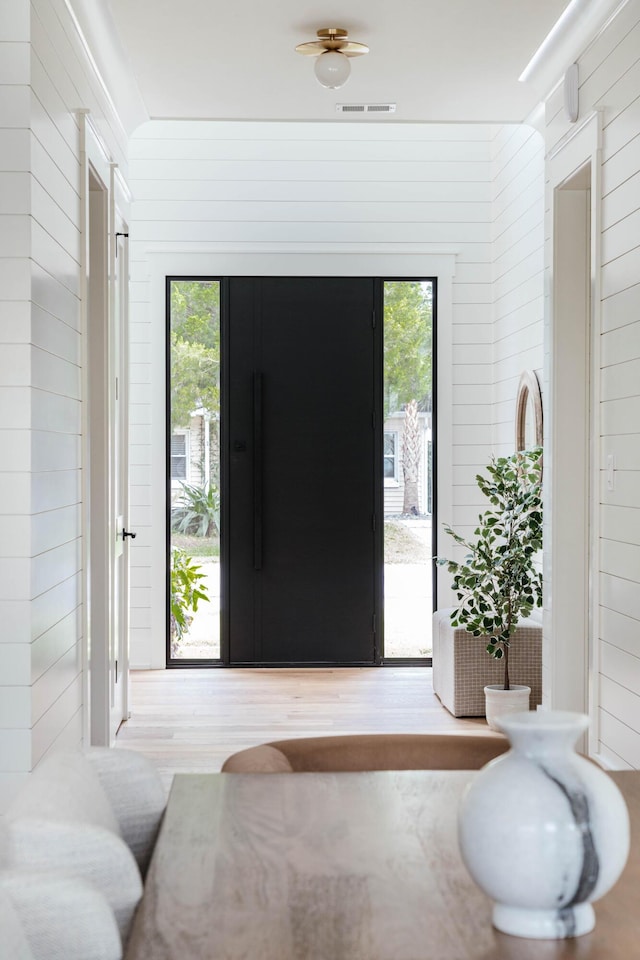 entryway with wood walls