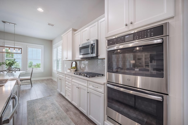 331 Fish Creek Ct, Summerville, SC 29486 - kitchen featuring appliances with stainless steel finishes, baseboards, tasteful backsplash, wood finished floors, and white cabinetry
