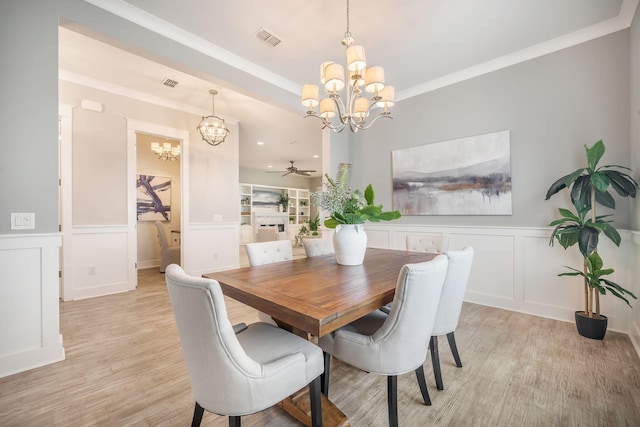 331 Fish Creek Ct, Summerville, SC 29486 - dining space featuring a chandelier, light wood finished floors, a ceiling fan, a decorative wall, and a wainscoted wall