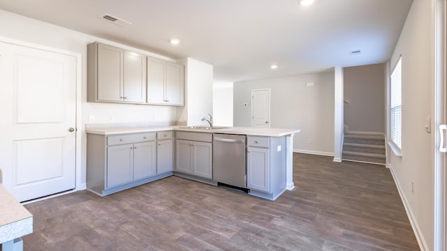 kitchen with dark hardwood / wood-style flooring, dishwasher, kitchen peninsula, sink, and gray cabinetry