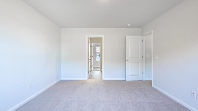 unfurnished room featuring light carpet