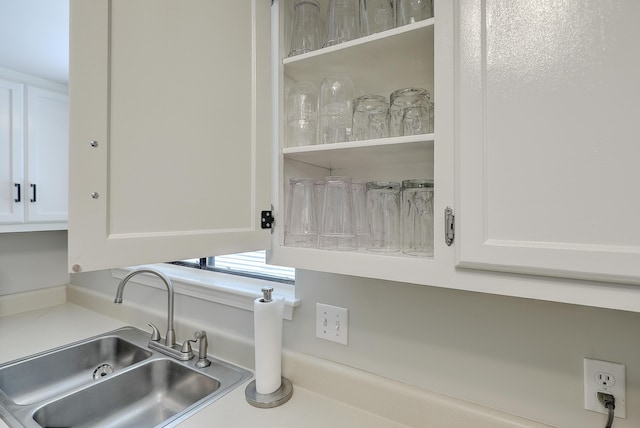 interior details featuring sink and white cabinets