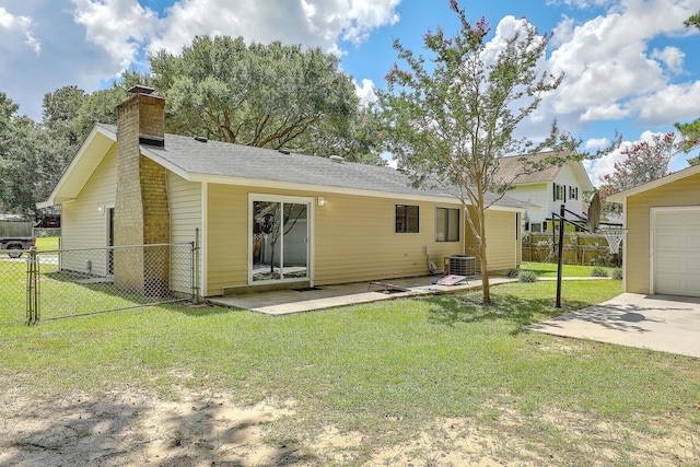 back of property with central AC, a patio area, and a lawn