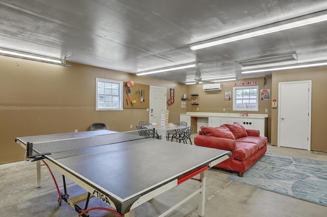 recreation room featuring a wall mounted AC and ceiling fan