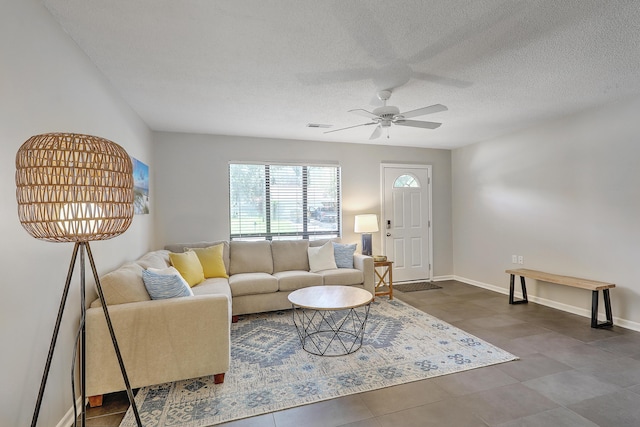 living room with ceiling fan and a textured ceiling