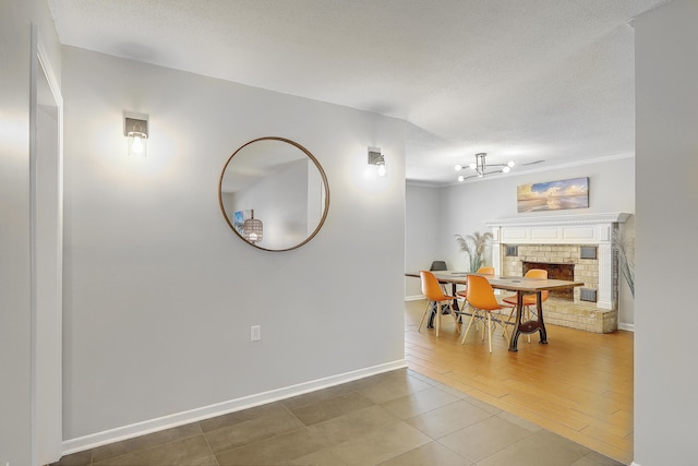 dining area with a brick fireplace, hardwood / wood-style floors, and a textured ceiling