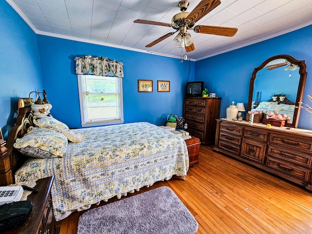 bedroom with ornamental molding, hardwood / wood-style floors, and ceiling fan