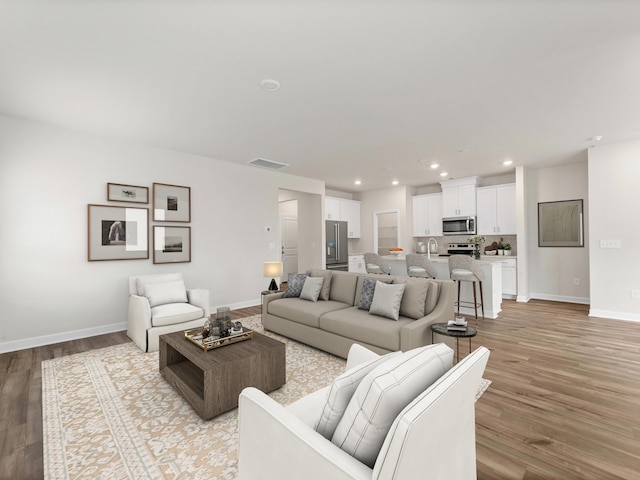 living room with light hardwood / wood-style flooring and sink