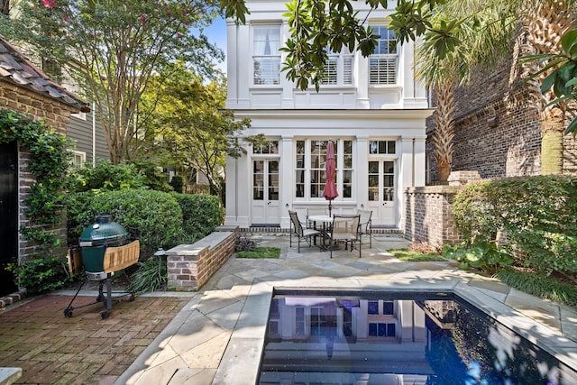 back of property with a patio, a balcony, and french doors