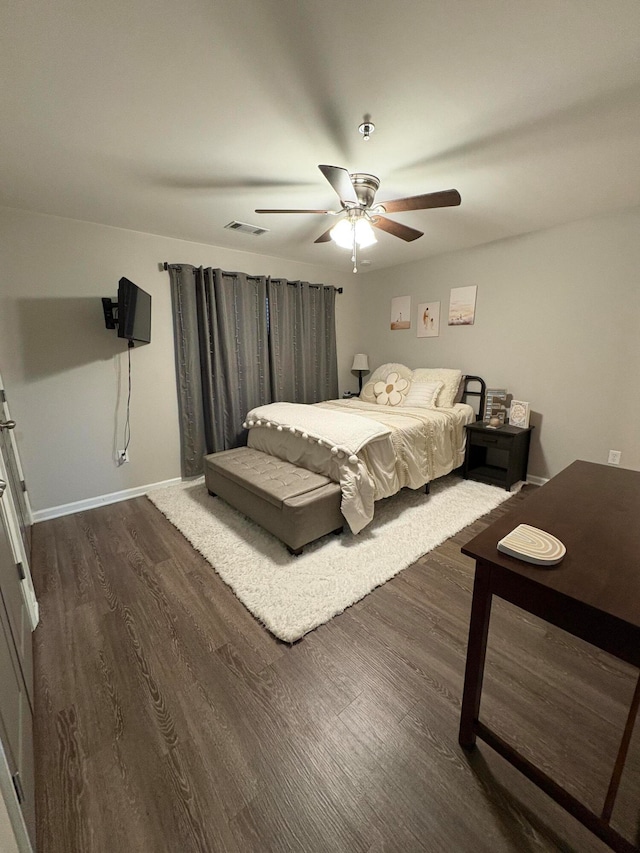 bedroom with dark hardwood / wood-style flooring and ceiling fan