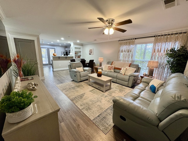 living room with ceiling fan, ornamental molding, and hardwood / wood-style floors