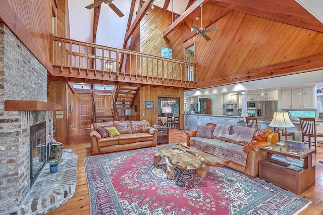 2287 Shoreline Dr, Johns Island, SC 29455 - living room featuring a ceiling fan, high vaulted ceiling, stairs, light wood finished floors, and a fireplace