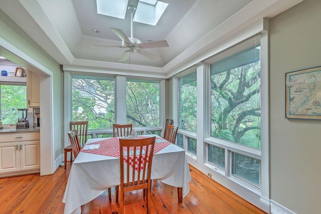 2287 Shoreline Dr, Johns Island, SC 29455 - dining area featuring a skylight, a tray ceiling, light wood finished floors, and ceiling fan