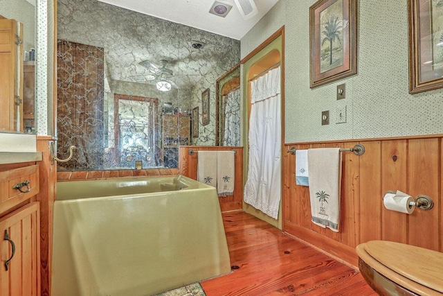 2287 Shoreline Dr, Johns Island, SC 29455 - bathroom with wood finished floors, a bath, a wainscoted wall, vanity, and ceiling fan