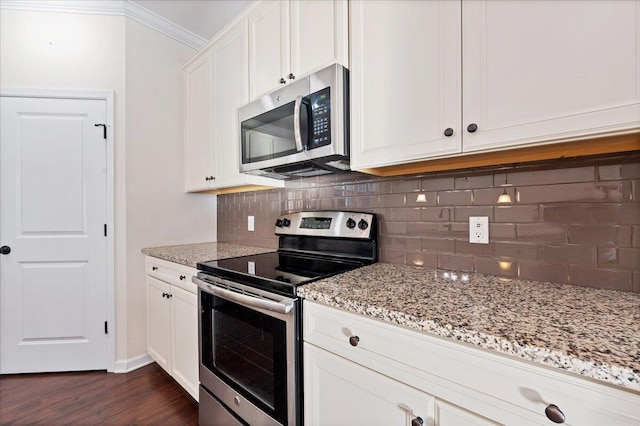 kitchen with appliances with stainless steel finishes, white cabinetry, light stone counters, and dark hardwood / wood-style flooring