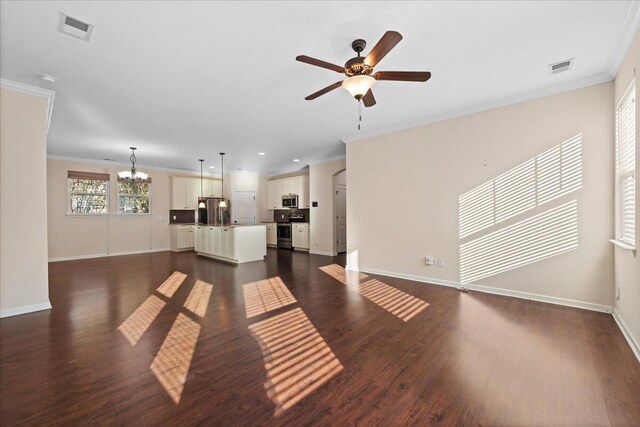 unfurnished living room with dark wood-type flooring, crown molding, and ceiling fan with notable chandelier