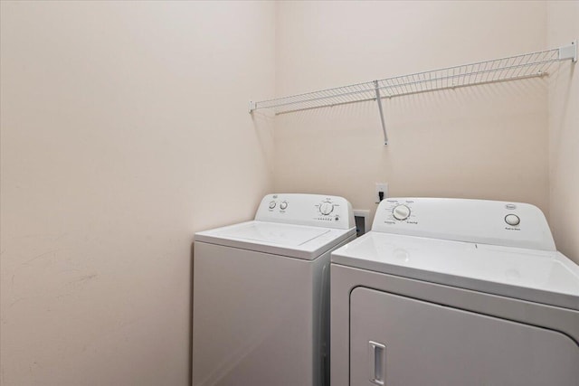 clothes washing area with washer and clothes dryer