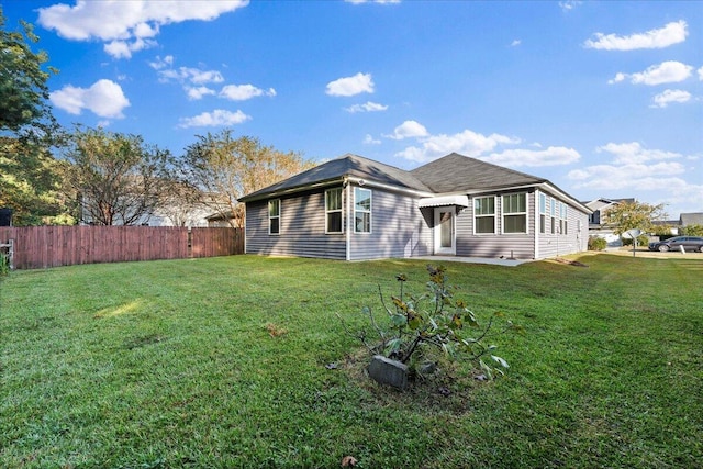 rear view of property featuring a lawn