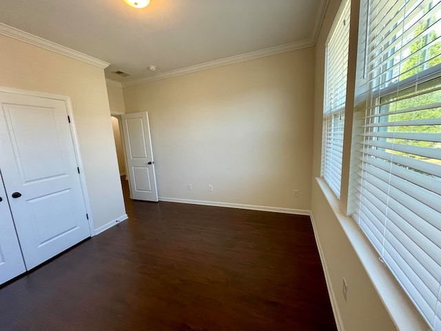 spare room featuring ornamental molding and dark hardwood / wood-style flooring