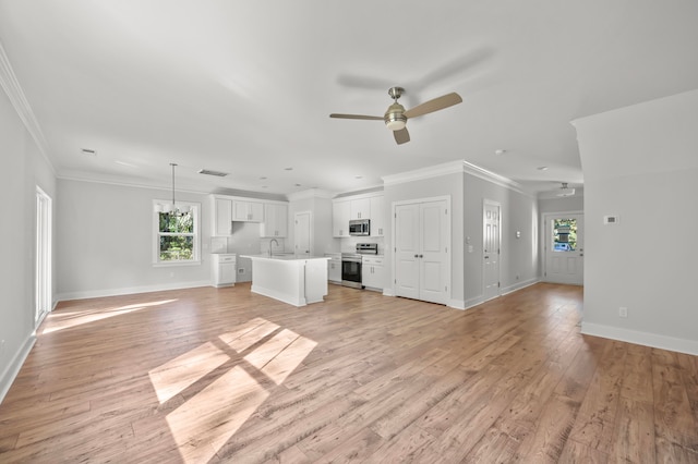 unfurnished living room featuring light wood-type flooring, ceiling fan, sink, and crown molding