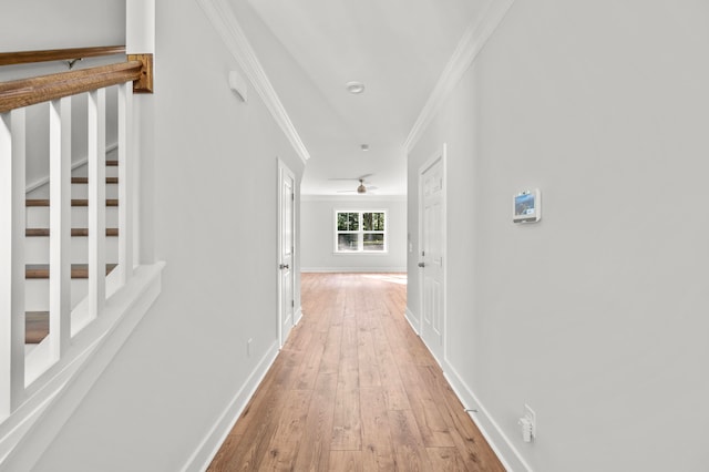 corridor with ornamental molding and hardwood / wood-style flooring