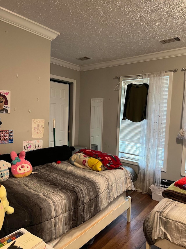 bedroom featuring ornamental molding, a textured ceiling, and dark hardwood / wood-style floors