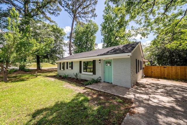 2219 Eagle Dr, North Charleston, SC 29406 - view of front of house featuring brick siding, fence, a shingled roof, and a front yard