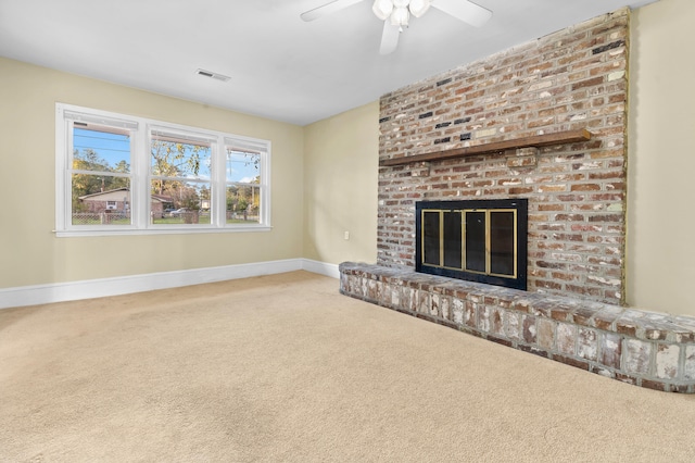 unfurnished living room featuring carpet flooring, ceiling fan, and a brick fireplace