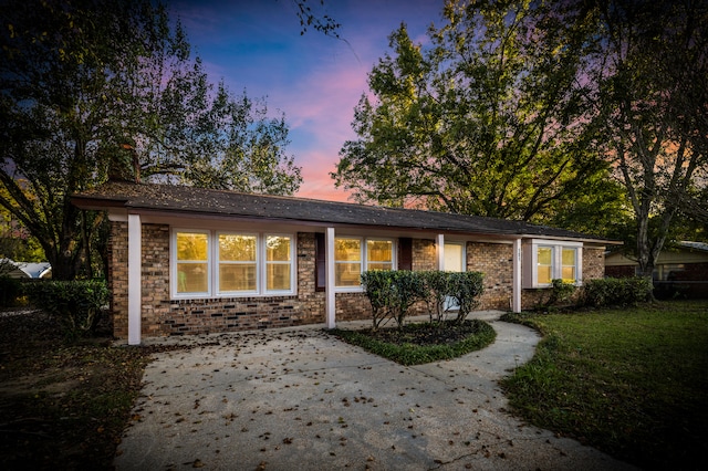 ranch-style home with a lawn