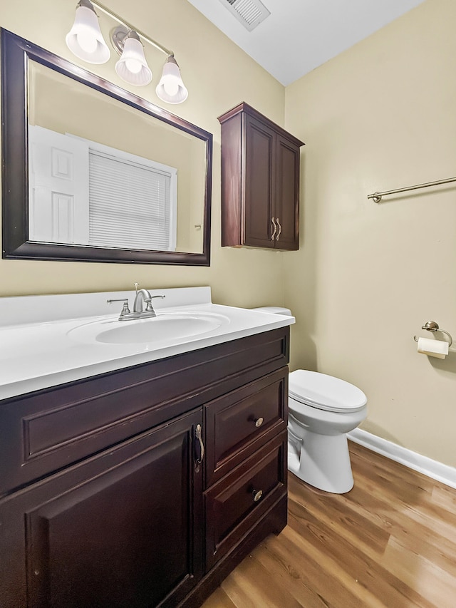 bathroom featuring hardwood / wood-style flooring, vanity, and toilet