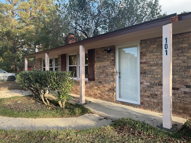 view of exterior entry with a porch