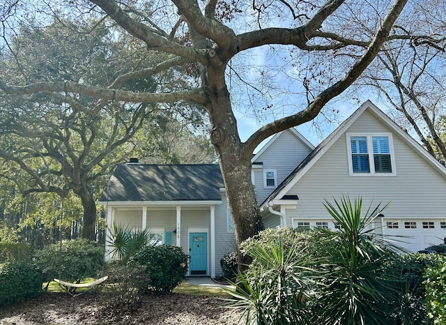 view of front of house featuring a garage and roof with shingles